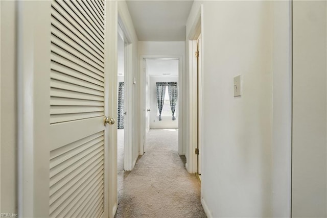 hall with light colored carpet