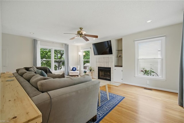 411 Rhode Island Ave, Norfolk, VA 23508 - living room featuring a ceiling fan, light wood-type flooring, a tiled fireplace, recessed lighting, and built in shelves