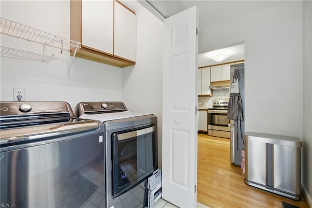 411 Rhode Island Ave, Norfolk, VA 23508 - clothes washing area with independent washer and dryer, light wood-style floors, and cabinet space
