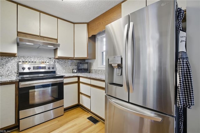 411 Rhode Island Ave, Norfolk, VA 23508 - kitchen featuring stainless steel appliances, under cabinet range hood, light wood-type flooring, a textured ceiling, and backsplash