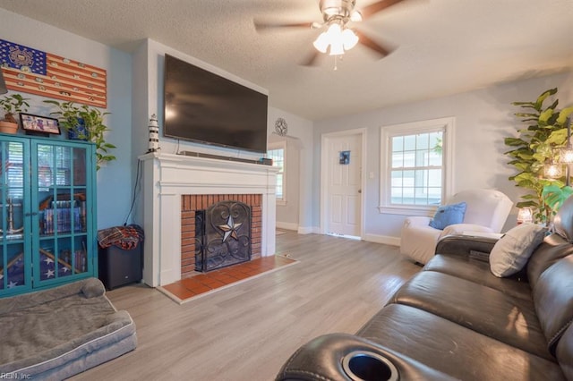 310 Manteo Ave, Hampton, VA 23661 - living area featuring wood finished floors, ceiling fan, a brick fireplace, a textured ceiling, and baseboards