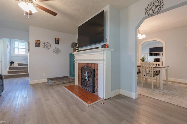 310 Manteo Ave, Hampton, VA 23661 - living room featuring wood finished floors, ceiling fan, a textured ceiling, stairs, and a fireplace