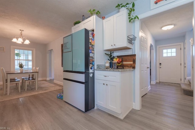 310 Manteo Ave, Hampton, VA 23661 - kitchen with freestanding refrigerator, a textured ceiling, white cabinetry, light wood-type flooring, and baseboards