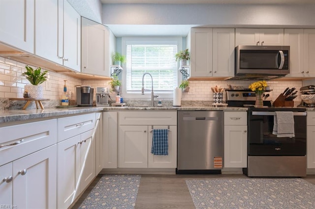310 Manteo Ave, Hampton, VA 23661 - kitchen with appliances with stainless steel finishes, a sink, backsplash, white cabinets, and light wood-style floors