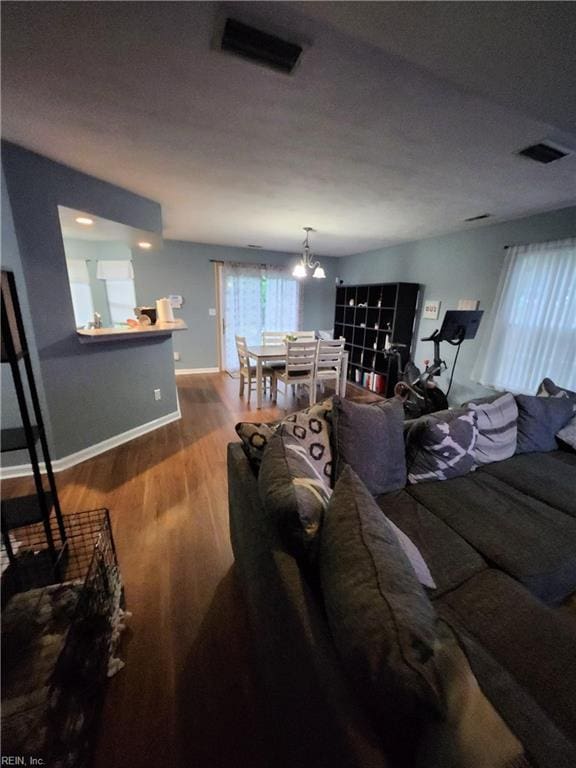 515 Burton St, Hampton, VA 23666 - living room featuring wood finished floors, a chandelier, and baseboards