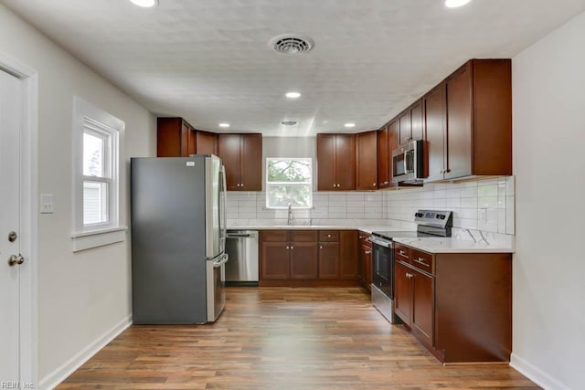208 George Washington Hwy N, Chesapeake, VA 23323 - kitchen featuring appliances with stainless steel finishes, tasteful backsplash, baseboards, light wood-type flooring, and recessed lighting