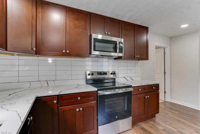 208 George Washington Hwy N, Chesapeake, VA 23323 - kitchen featuring stainless steel appliances, decorative backsplash, baseboards, light wood-type flooring, and light stone counters