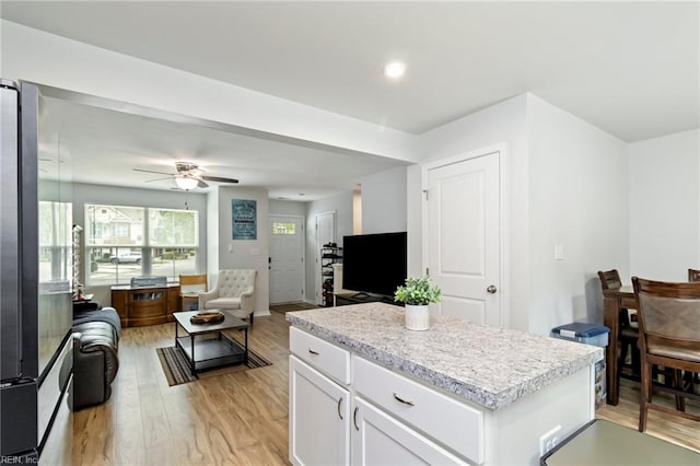 kitchen with open floor plan, light wood-style flooring, and light countertops