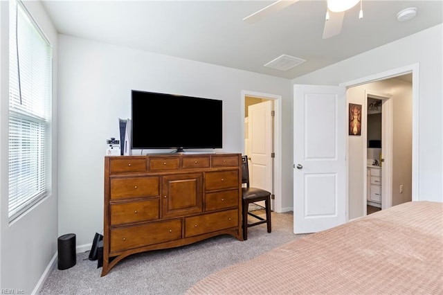 bedroom featuring light carpet, baseboards, ceiling fan, and connected bathroom