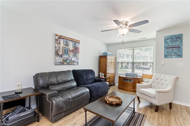 living area featuring ceiling fan, light wood-type flooring, and baseboards