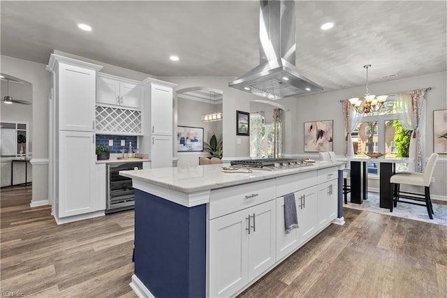 2300 Perez Way, Virginia Beach, VA 23456 - kitchen featuring island exhaust hood, beverage cooler, stainless steel gas cooktop, arched walkways, and light wood finished floors