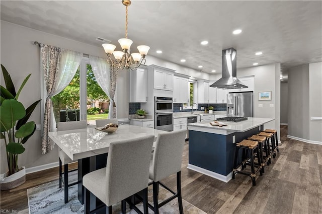 2300 Perez Way, Virginia Beach, VA 23456 - kitchen featuring appliances with stainless steel finishes, a chandelier, light countertops, island range hood, and a kitchen island