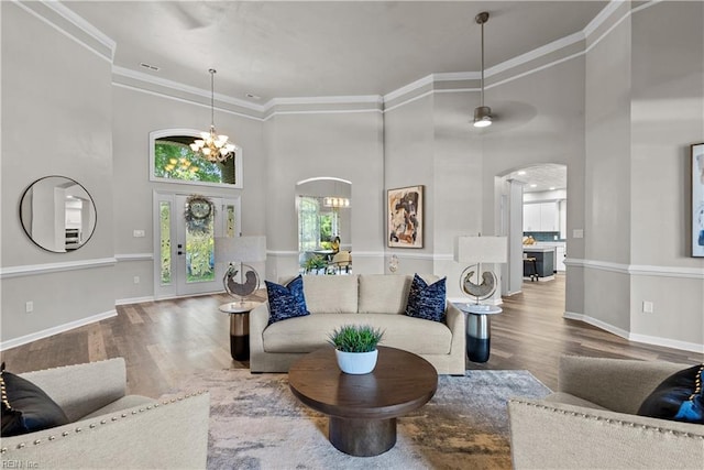 2300 Perez Way, Virginia Beach, VA 23456 - living room featuring arched walkways, wood finished floors, a chandelier, a high ceiling, and baseboards