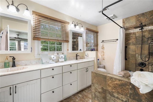 4769 Marlborough Dr, Virginia Beach, VA 23464 - bathroom featuring tiled shower, double vanity, stone finish floors, and toilet