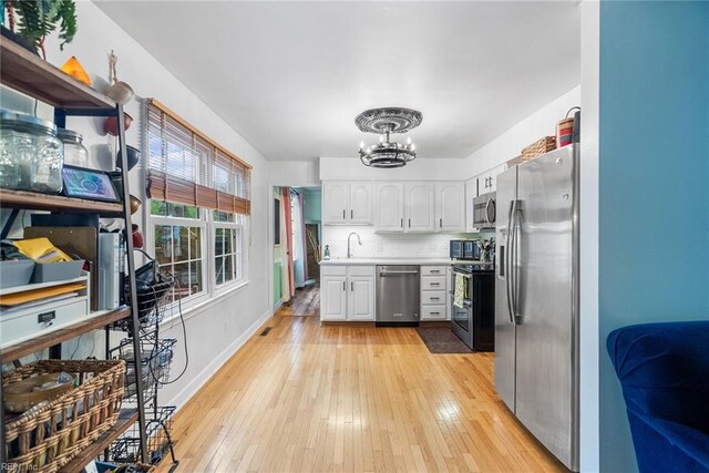 4769 Marlborough Dr, Virginia Beach, VA 23464 - kitchen featuring stainless steel appliances, a chandelier, white cabinets, light countertops, and light wood-style flooring
