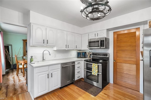 4769 Marlborough Dr, Virginia Beach, VA 23464 - kitchen featuring stainless steel appliances, a sink, light wood-type flooring, a chandelier, and light countertops