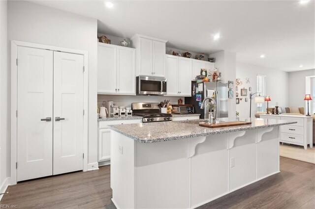 109 Big Woods Dr, Poquoson, VA 23662 - kitchen with appliances with stainless steel finishes, wood finished floors, an island with sink, white cabinets, and recessed lighting