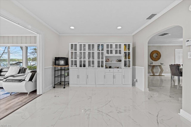 sitting room featuring arched walkways, baseboards, light marble finish flooring, recessed lighting, and crown molding