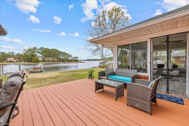 wooden deck featuring a water view, a lawn, and a sunroom