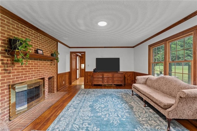 104 Beechwood Dr, Franklin, VA 23851 - living area with a wainscoted wall, wood finished floors, crown molding, and a brick fireplace