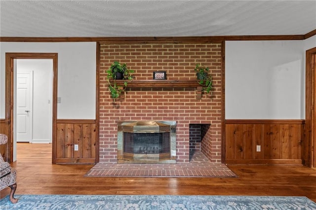 104 Beechwood Dr, Franklin, VA 23851 - unfurnished living room featuring a wainscoted wall, wood-type flooring, a fireplace, ornamental molding, and wood walls