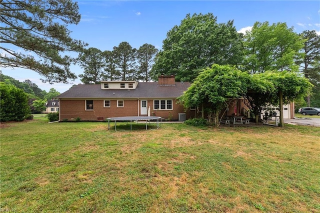 104 Beechwood Dr, Franklin, VA 23851 - rear view of house with a trampoline, brick siding, a yard, cooling unit, and a chimney