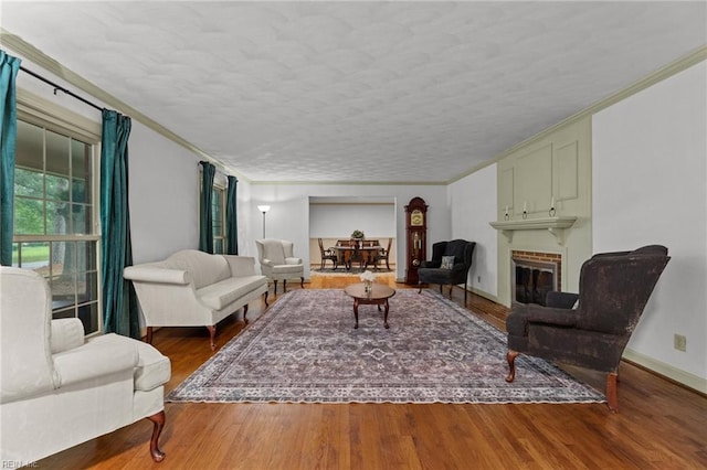 104 Beechwood Dr, Franklin, VA 23851 - living room featuring a fireplace, wood finished floors, ornamental molding, a textured ceiling, and baseboards