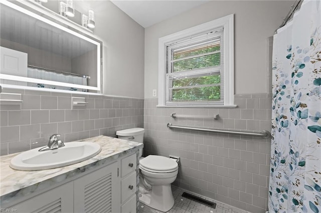 1508 Reynard Rd, Suffolk, VA 23433 - bathroom with tile walls, tile patterned flooring, toilet, vanity, and wainscoting