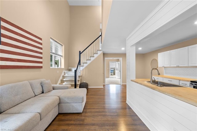 living room with dark wood finished floors, stairs, recessed lighting, and baseboards