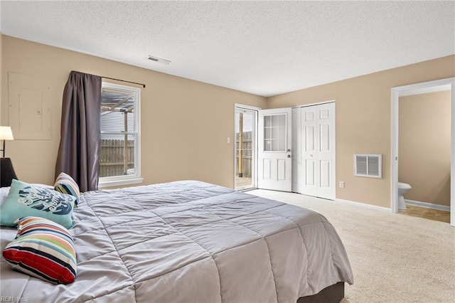 bedroom featuring carpet, a textured ceiling, a closet, ensuite bath, and baseboards