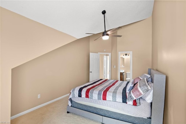 carpeted bedroom with vaulted ceiling, baseboards, ensuite bath, and ceiling fan