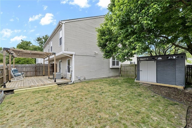 rear view of house featuring a wooden deck, a pergola, an outbuilding, and a storage unit