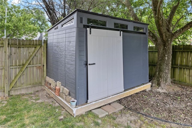 view of shed with a fenced backyard and a gate