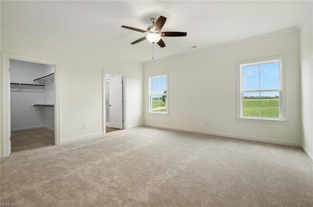 104 Pailin Creek Rd, Elizabeth City, NC 27909 - unfurnished bedroom featuring crown molding, carpet flooring, baseboards, a walk in closet, and ceiling fan