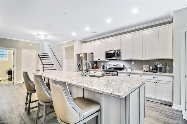 3820 Whites Lndg, Chesapeake, VA 23321 - kitchen featuring appliances with stainless steel finishes, a sink, a center island with sink, light wood-style floors, and a kitchen breakfast bar