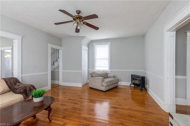 113 E Virginia Ave, Hampton, VA 23663 - sitting room featuring stairs, ceiling fan, hardwood / wood-style floors, a wood stove, and wainscoting