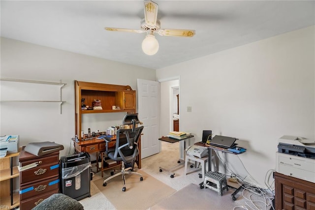 office featuring a ceiling fan and light carpet