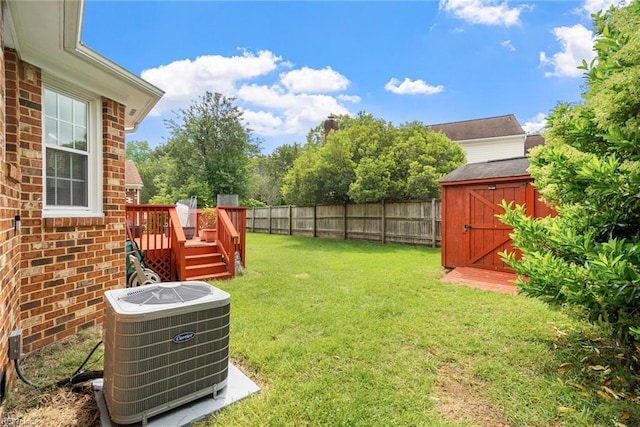 view of yard featuring cooling unit, a storage unit, a deck, and an outbuilding