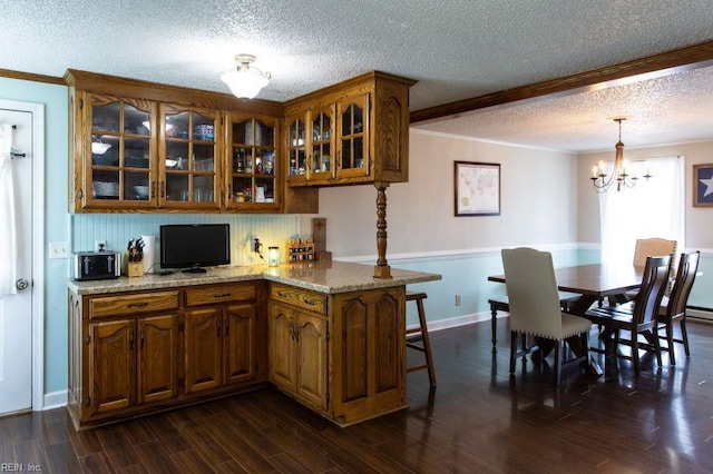 125 Messick Rd, Poquoson, VA 23662 - kitchen featuring a textured ceiling, brown cabinetry, ornamental molding, glass insert cabinets, and a chandelier