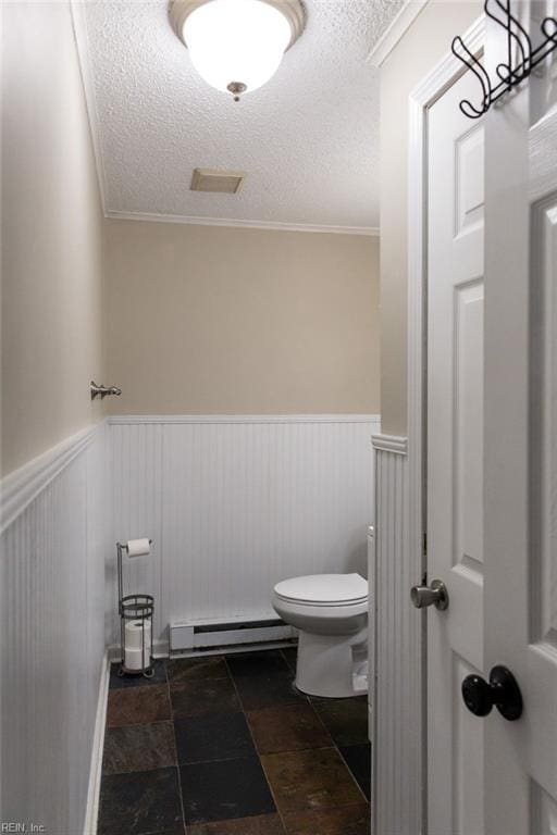 125 Messick Rd, Poquoson, VA 23662 - bathroom featuring a baseboard radiator, a textured ceiling, toilet, a wainscoted wall, and crown molding