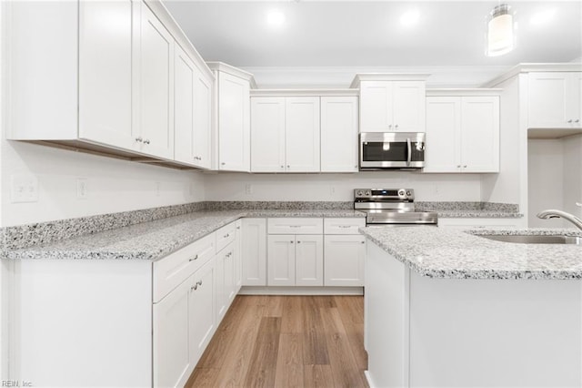 3127 Lens Ave, Norfolk, VA 23509 - kitchen featuring appliances with stainless steel finishes, light wood-style floors, white cabinetry, light stone countertops, and a sink