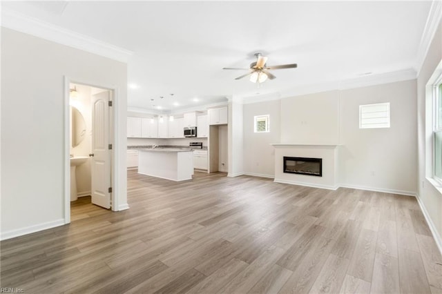 3127 Lens Ave, Norfolk, VA 23509 - unfurnished living room with ornamental molding, a ceiling fan, plenty of natural light, light wood-style floors, and a glass covered fireplace
