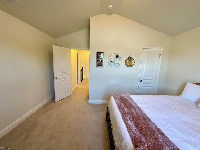 bedroom with vaulted ceiling, baseboards, and light colored carpet