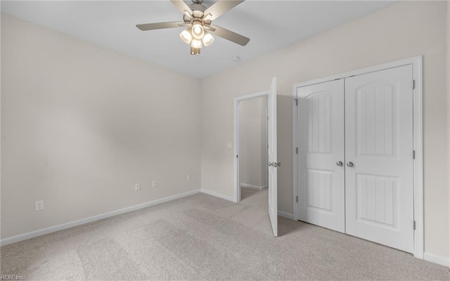unfurnished bedroom featuring light colored carpet, baseboards, a closet, and ceiling fan