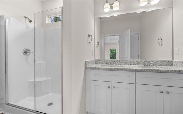 bathroom featuring a shower stall, healthy amount of natural light, and double vanity