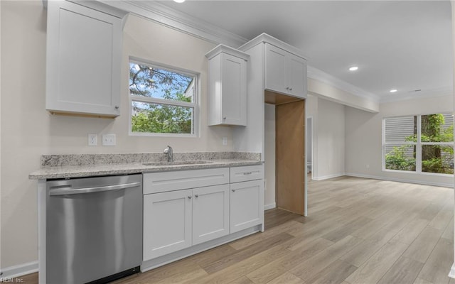 kitchen featuring stainless steel dishwasher, a sink, crown molding, light wood finished floors, and white cabinets