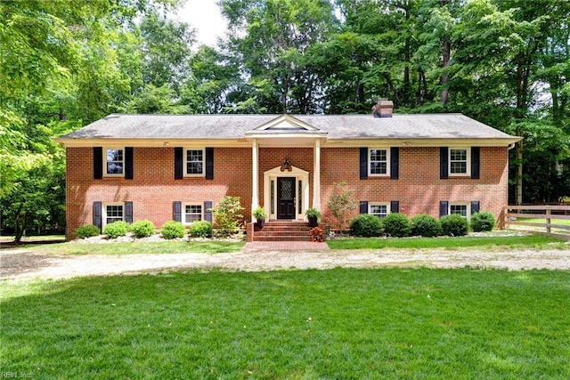 142 Little John Rd, Williamsburg, VA 23185 - split foyer home with brick siding, a chimney, and view of scattered trees