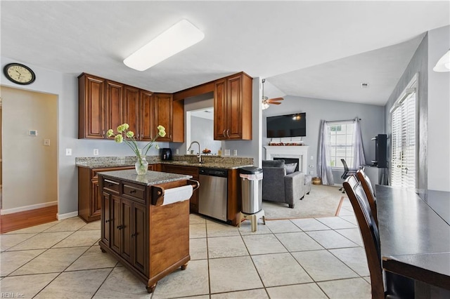 6701 Burbage Landing Cir, Suffolk, VA 23435 - kitchen with stainless steel dishwasher, light tile patterned flooring, ceiling fan, dark stone counters, and a sink