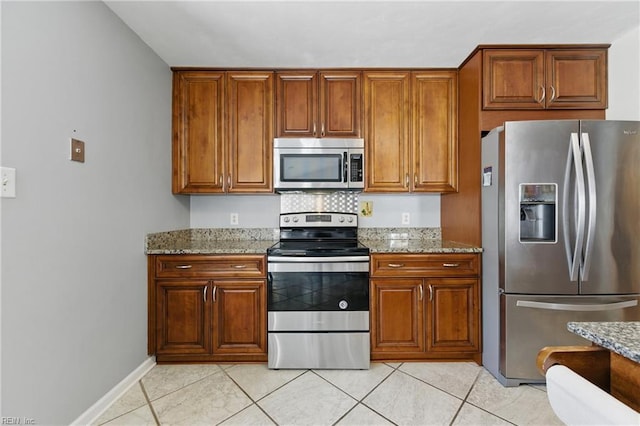 6701 Burbage Landing Cir, Suffolk, VA 23435 - kitchen featuring stainless steel appliances, brown cabinets, light tile patterned flooring, and light stone countertops