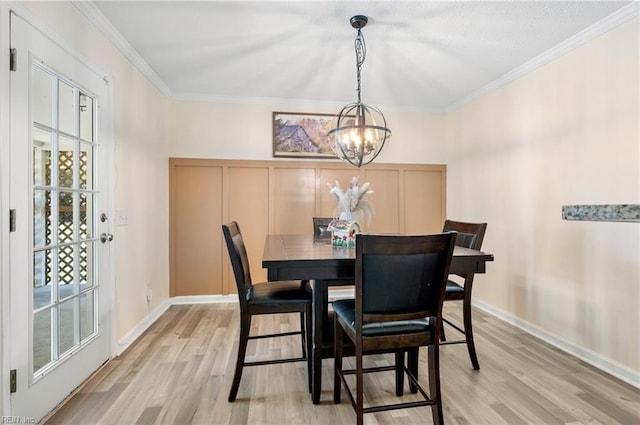 504 Amster Ln, Chesapeake, VA 23323 - dining space with a chandelier, light wood finished floors, ornamental molding, a decorative wall, and baseboards